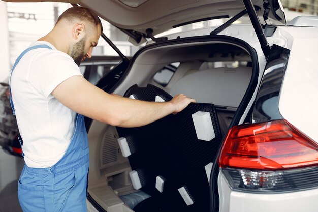 Bel homme en uniforme bleu vérifie la voiture