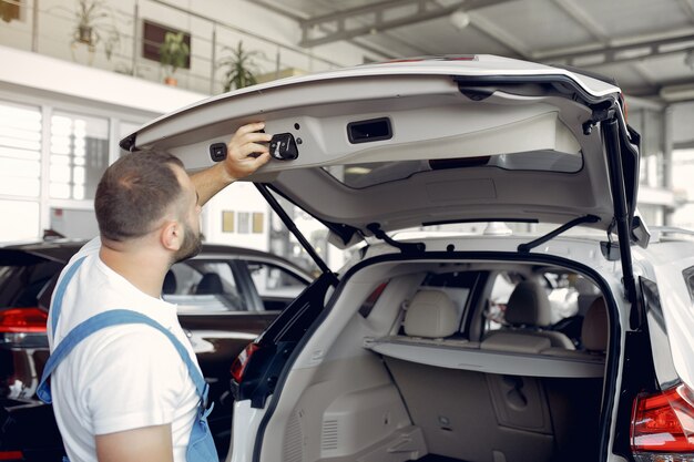 Bel homme en uniforme bleu vérifie la voiture