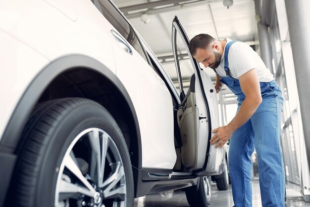 Bel homme en uniforme bleu vérifie la voiture