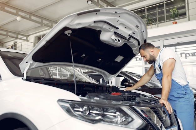 Bel homme en uniforme bleu vérifie la voiture