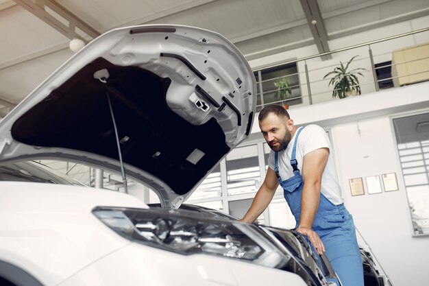 Bel homme en uniforme bleu vérifie la voiture