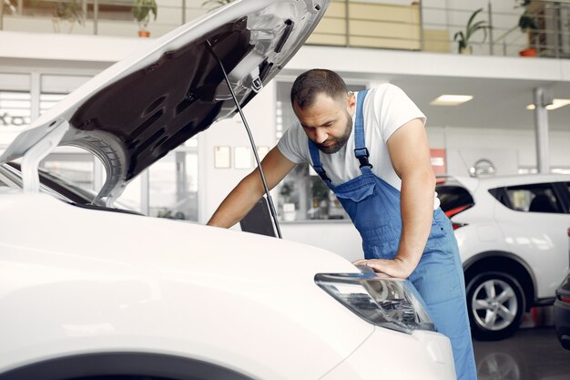 Bel homme en uniforme bleu vérifie la voiture