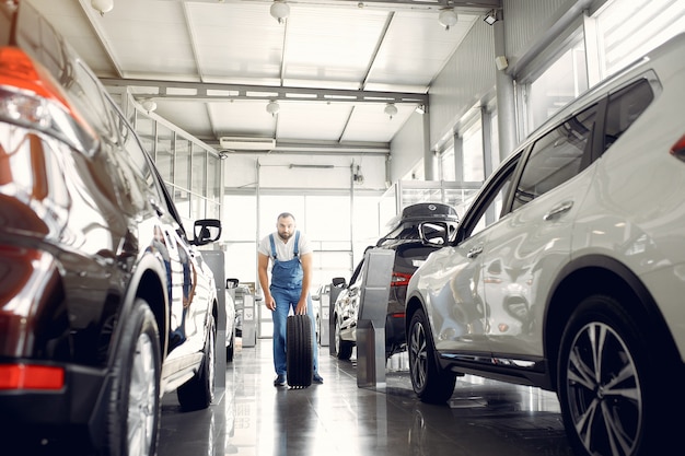 Bel homme en uniforme bleu vérifie la voiture