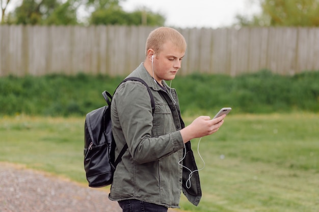 Bel homme utilise un téléphone mur extérieur en bois