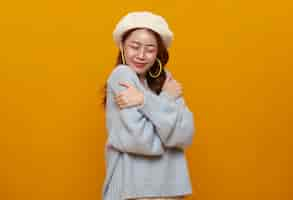 Photo gratuite belle adolescente asiatique femme étreignant et s'embrassant isolée sur fond jaune studio