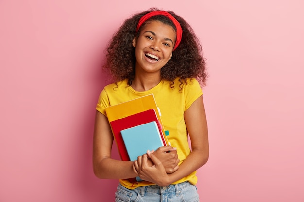 Photo gratuite belle adolescente aux cheveux bouclés posant en tshirt jaune