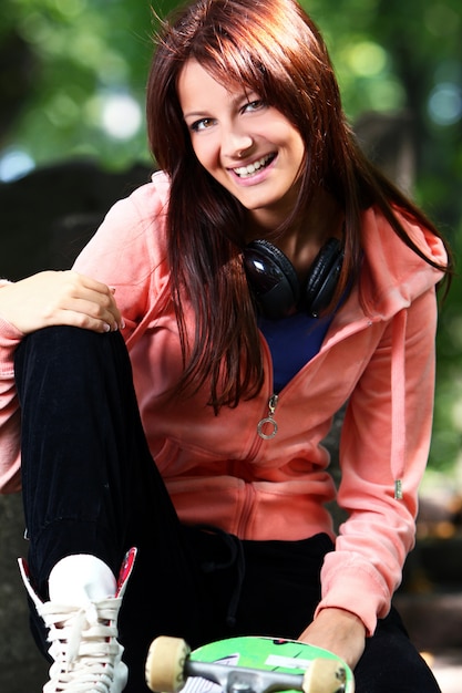 Belle adolescente avec un casque dans le parc