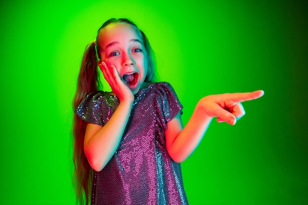 Belle adolescente à la surprise isolé sur mur vert