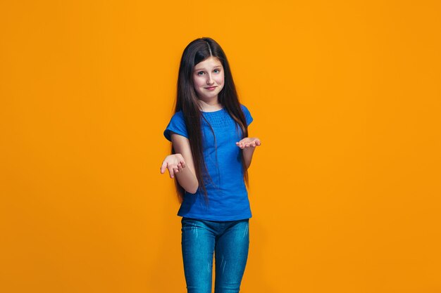 Belle adolescente à la surprise et perplexe isolé sur orange