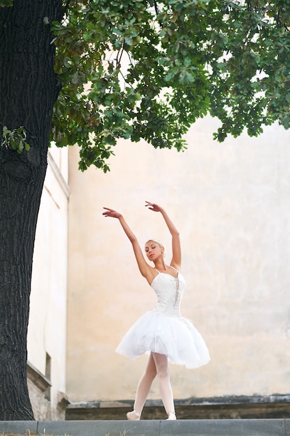 Belle ballerine gracieuse dansant dans les rues d'un vieux ci