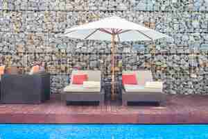 Photo gratuite belle chaise de luxe avec parasol et piscine