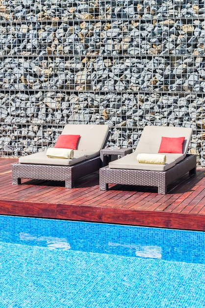 Photo gratuite belle chaise de luxe avec parasol et piscine