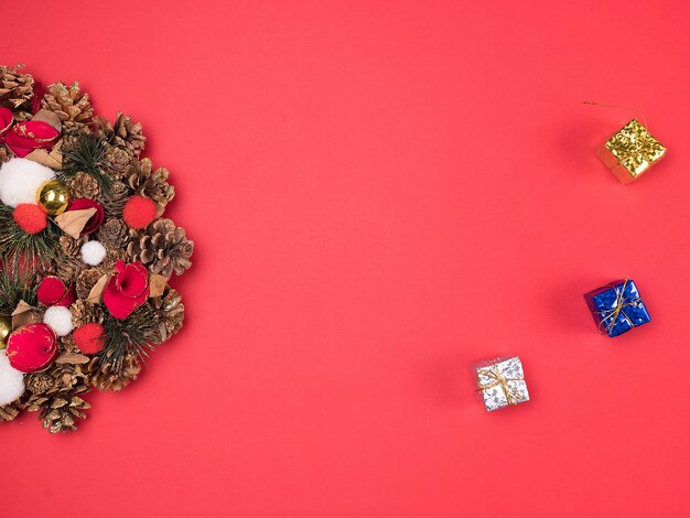 Belle couronne de Noël avec de petits coffrets cadeaux sur fond rouge. Décoration intérieure festive