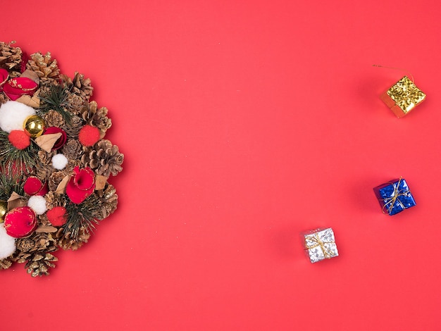 Belle couronne de Noël avec de petits coffrets cadeaux sur fond rouge. Décoration intérieure festive