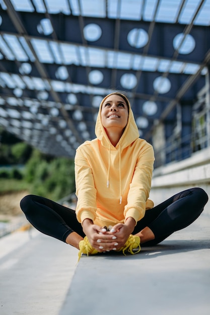 Belle dame active en vêtements de sport assis sur les marches