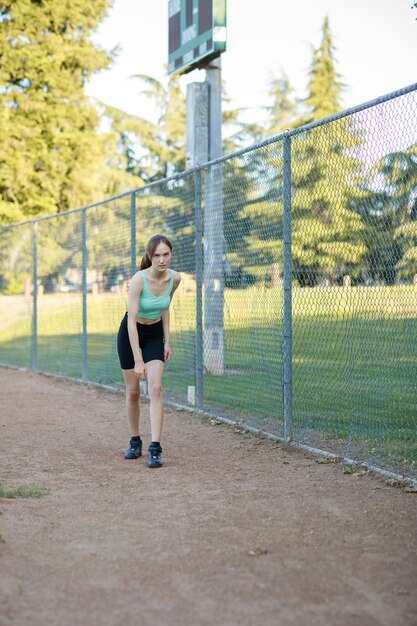 Belle dame debout dans le parc et regardant la caméra