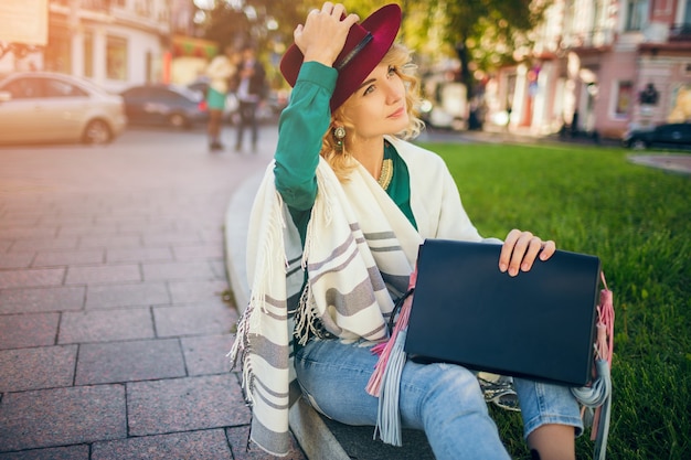 Photo gratuite belle dame élégante marchant dans la rue en cape tenant le sac à main, accessoires de mode, tendance de style de rue de printemps, souriant