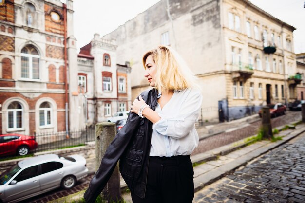 La belle dame gardant une veste et debout dans la rue