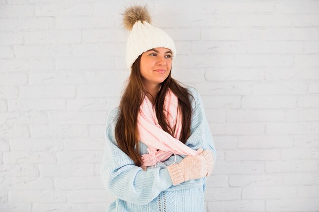 Belle dame en mitaines, bonnet et écharpe avec les mains qui se croisent