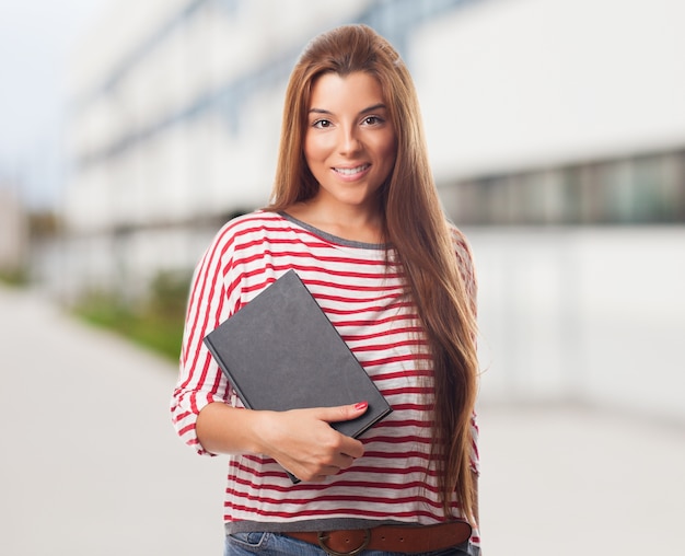 Belle étudiant posant avec bloc-notes