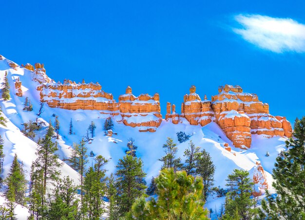 Belle falaise rocheuse couverte de neige avec l'incroyable ciel bleu clair