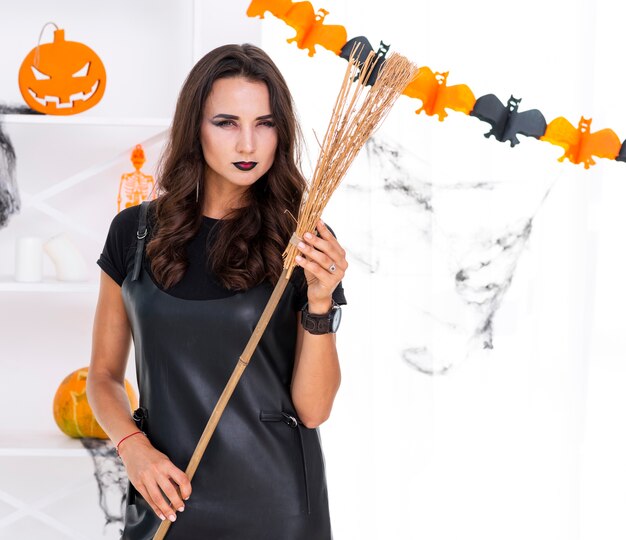 Belle femme adulte avec balai d'halloween