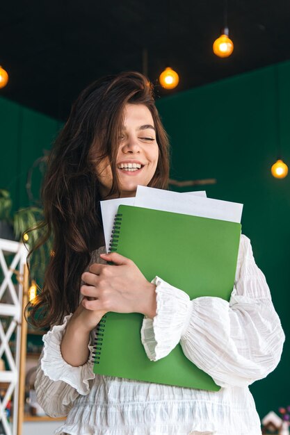 Belle femme d'affaires avec un dossier de papiers dans un intérieur vert