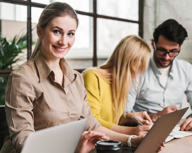 Belle femme d'affaires posant lors d'une réunion à l'intérieur