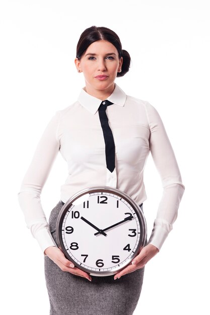 Belle femme d'affaires tenant une horloge