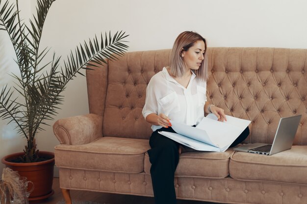 Belle femme d'affaires travaillant à la maison. Concept multitâche, indépendant et maternité