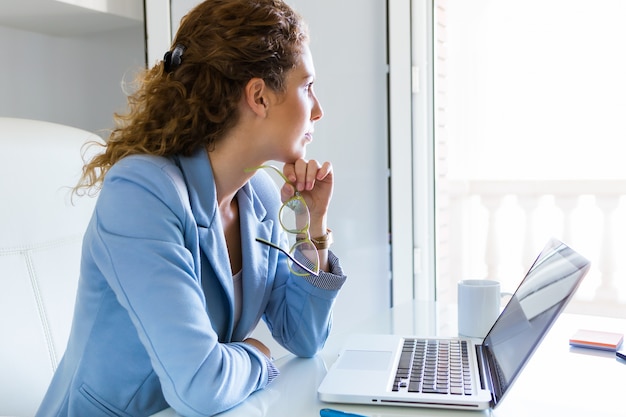 Belle femme d&#39;affaires travaillant avec son ordinateur portable au bureau.