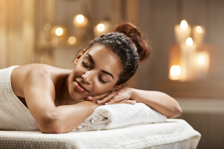 Photo gratuit belle femme africaine au repos relaxante dans une station thermale avec les yeux fermés.