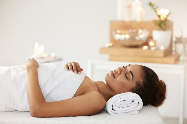 Belle femme africaine couchée dans un salon spa