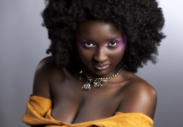 Photo gratuite belle femme africaine avec de grands afro bouclés et des fleurs dans ses cheveux