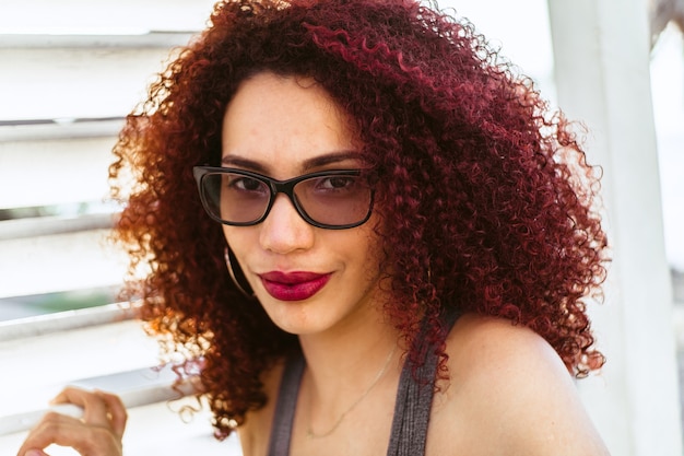 Belle femme afro-américaine aux cheveux roux bouclés posant