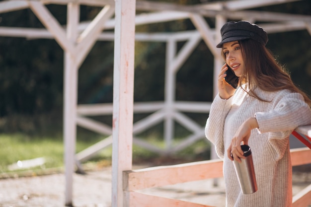 Photo gratuite belle femme à l'aide de téléphone et de boire du thé