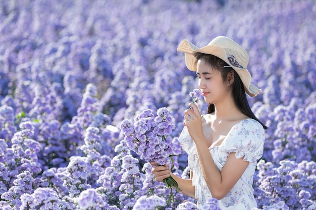 Belle femme appréciant le champ de fleurs