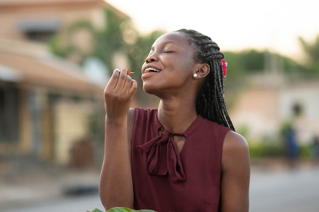 Belle femme appréciant de la nourriture de rue