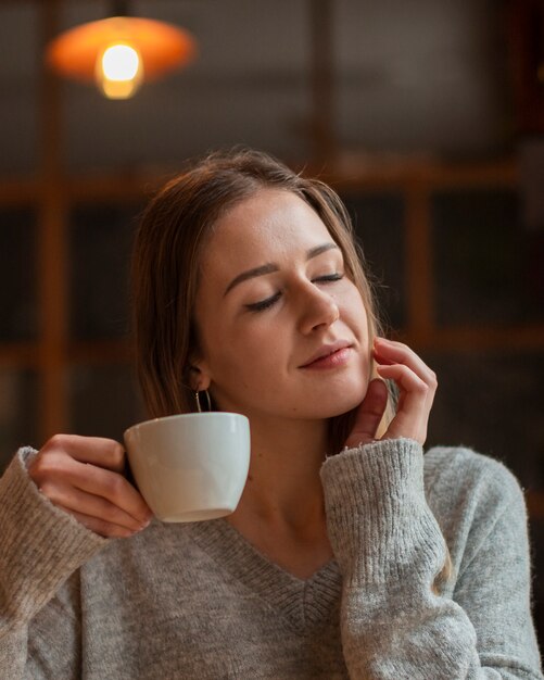 Belle femme appréciant la tasse de café