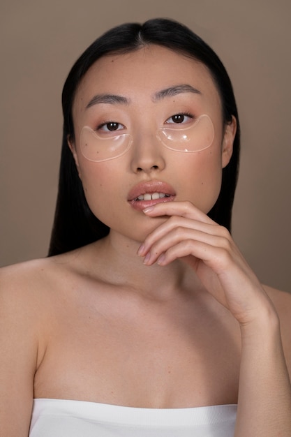 Photo gratuite belle femme asiatique appliquant un traitement de la peau