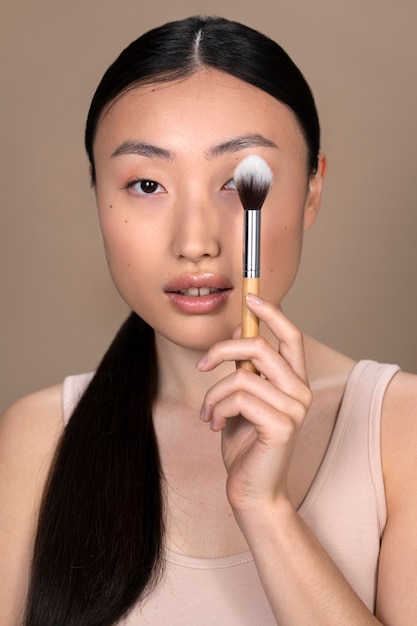 Photo gratuite belle femme asiatique, appliquer le maquillage