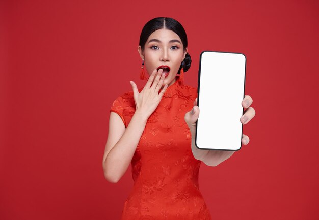 Une belle femme asiatique chinoise excitée tenant une maquette d'écran vide d'un smartphone