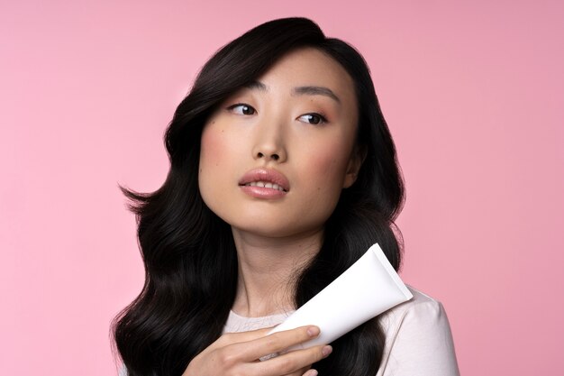 Belle femme asiatique avec crème pour le visage