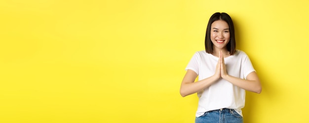 Photo gratuite belle femme asiatique dit merci en se tenant la main dans le geste de prière de namaste et en souriant en étant reconnaissant