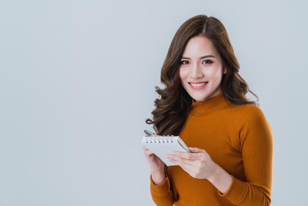 Belle femme asiatique écrire une note sur papier avec bonheur et moment de joie isoler fond blanc