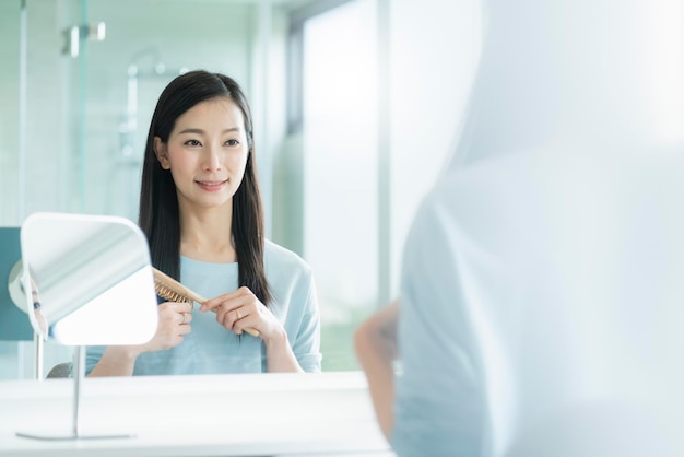 Belle Femme Asiatique Maquillage Et Coiffure Avec Miroir Dans La Salle De Bain Avec Lumière Du Matin