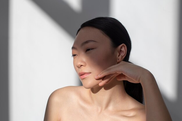 Belle femme asiatique posant avec une peau parfaite