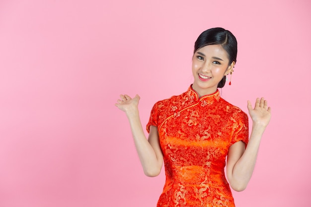 Belle femme asiatique sourire heureux et se sentir excité au nouvel an chinois sur fond rose.