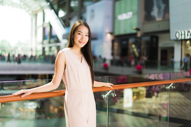 Belle femme asiatique sourit et heureuse au centre commercial