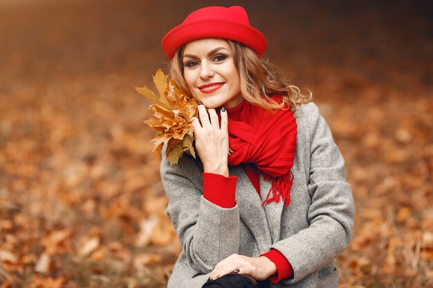 Belle femme assise dans un parc en automne